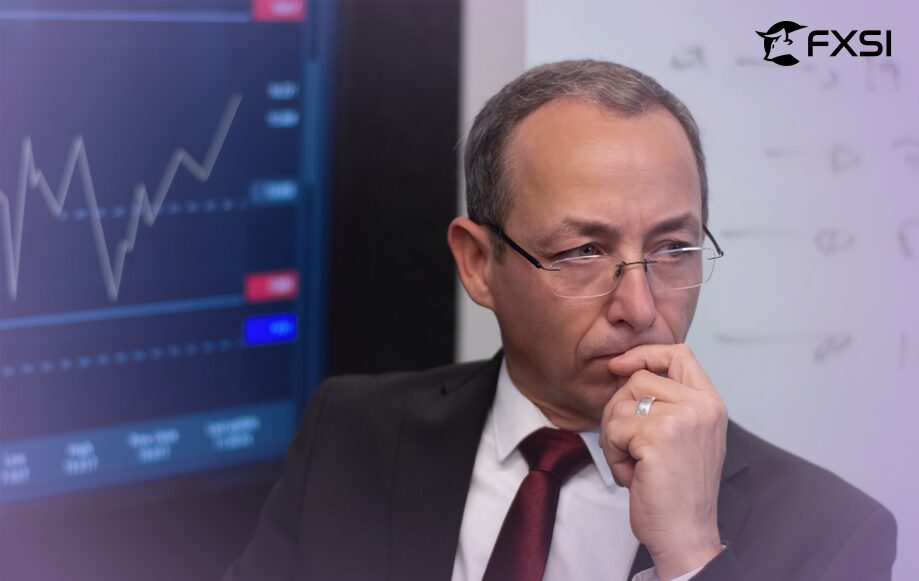 Man in a thoughtful pose with a screen displaying stock prices and financial data in the background