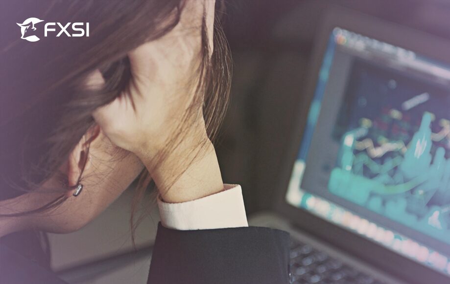 Woman holding her head with a stressed expression, reflecting the emotional challenges of online trading psychology.