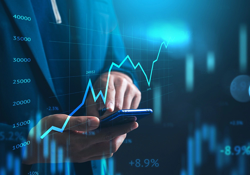 How to Develop a Long-Term Investing Mindset – Complete Guide 2 Hand holding smartphone with rising financial chart showing investment growth and returns