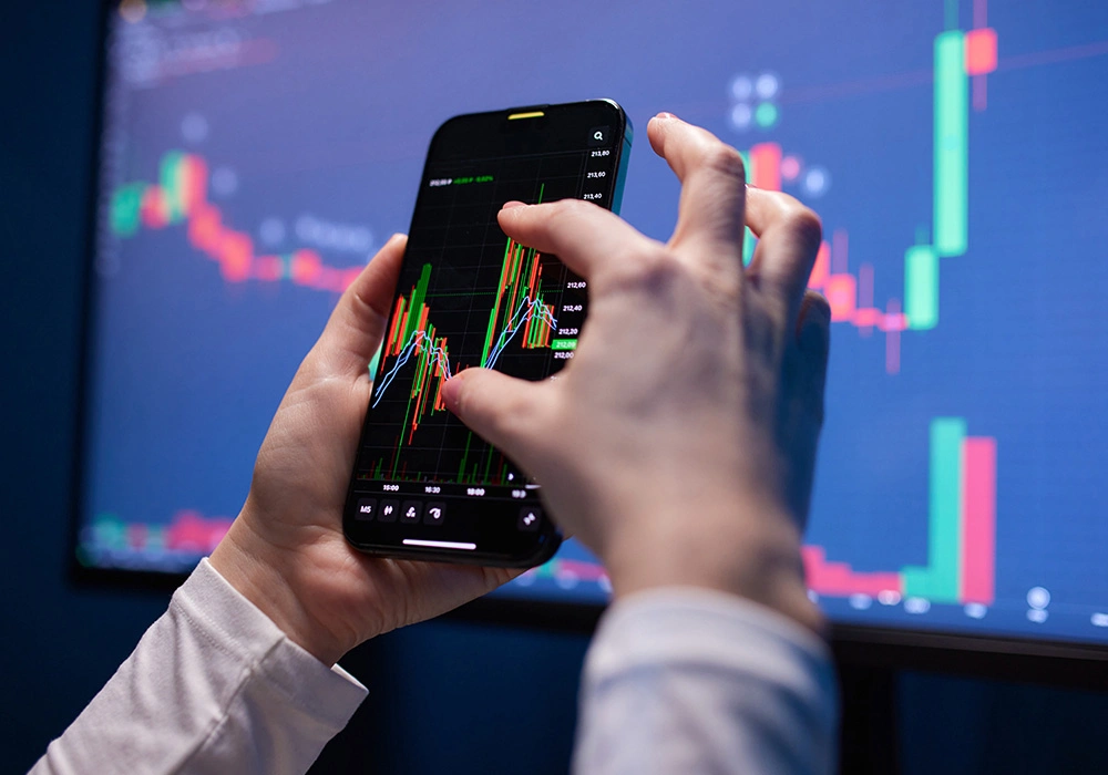 Navigating Market Volatility with a Long-Term Investment View 2 Person using smartphone to analyze stock chart with candlesticks and indicators